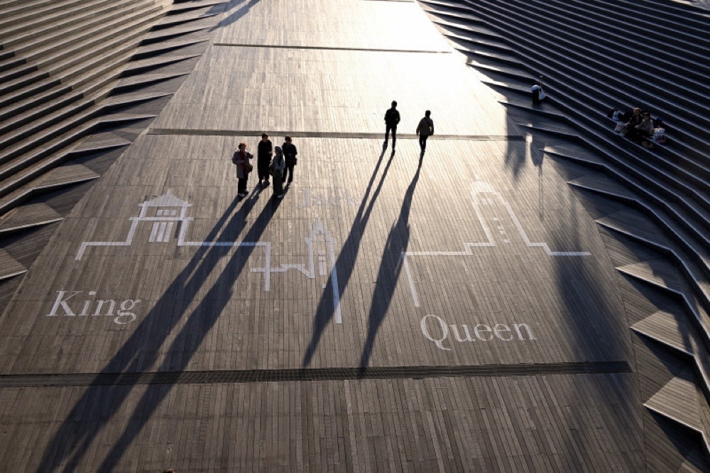 大さん橋の三塔が見えるペイントされた目印と人と長く伸びた影。